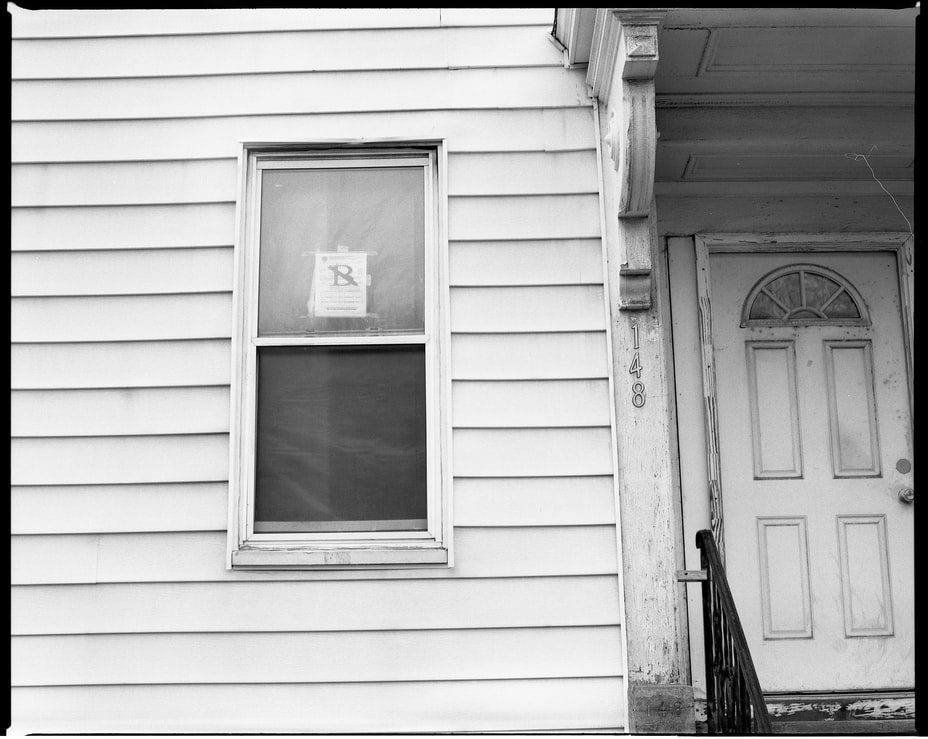 Black and white image of a house’s front door and window 